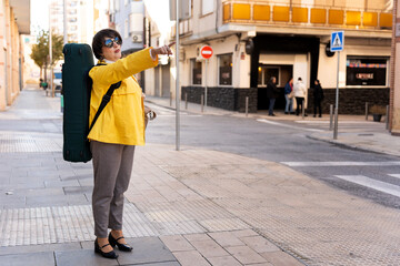 Fototapeta premium Woman musician pointing direction in city street