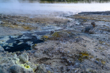 Bubbling geothermal landscape in Russia with steam and minerals at sunset