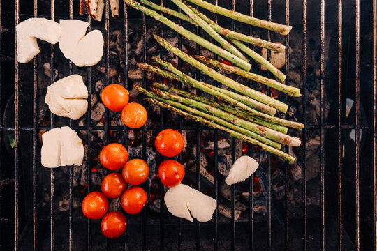 Directly above shot of cherry tomato, feta cheese and asparagus on barbecue grill