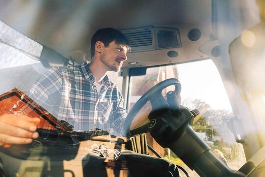 Farmer driving tractor while working at farm