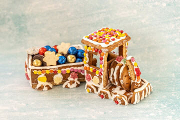 Homemade gingerbread train decorated with icing and colorful candies, filled with festive Christmas cookies and chocolate balls