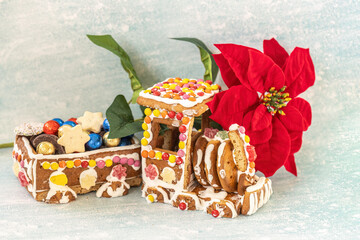 Gingerbread train with poinsettia flower and Christmas cookies on light blue background
