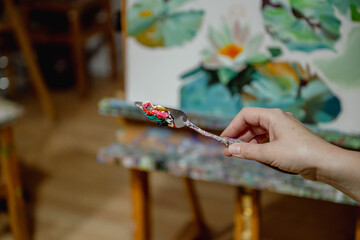 Artist’s palette knife with colorful oil paints against a blurred painting background, perfect for art, creativity, and painting themes.

