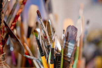 Close-up of a bunch of colorful artist paintbrushes in a studio. Creative art tools with paint marks and soft focus background, symbolizing inspiration and creativity.
