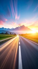 Naklejka premium Scenic sunset view of a winding road leading to majestic mountains under a vibrant sky