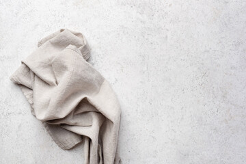 Grey linen textile on grey stone background. Top view copy space. Food background, web banner