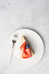 Strawberry cheesecake on a plate, top view copy space