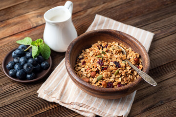Homemade granola with dried fruits, pumpkin seeds and almond nuts in wooden bowl. Healthy food