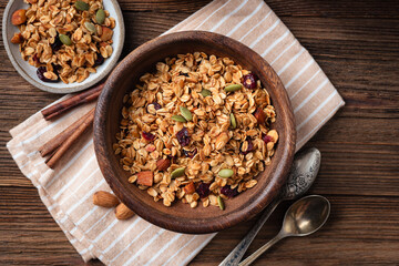 Homemade granola with dried fruits, pumpkin seeds and almond nuts in wooden bowl. Healthy food