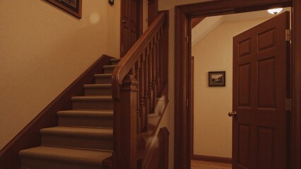 Fototapeta premium Staircase and door inside a house with warm lighting. Interior design and architecture concept. Home interior and wooden details. The concept of house planning and decor.