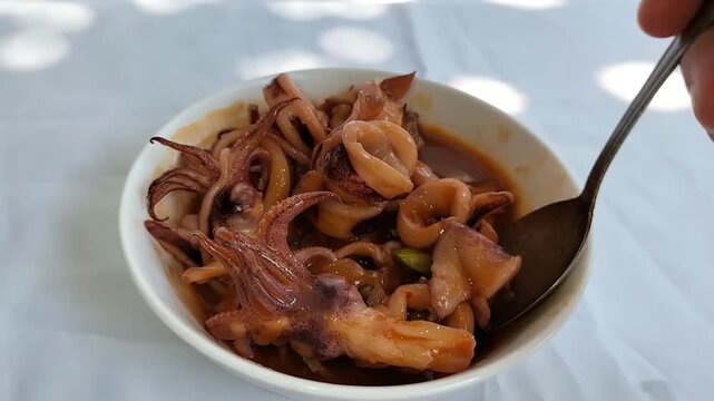A bowl of squid in sweet and sour sauce. Seafood typical of Asian cuisine. Footage.