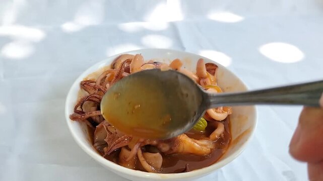 A bowl of squid in sweet and sour sauce. Seafood typical of Asian cuisine. Footage.