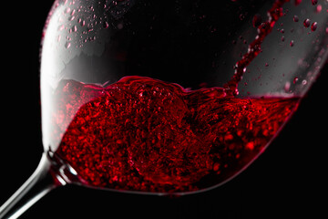 Red wine is poured into a glass.