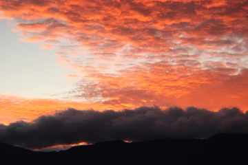 Selbstklebende Fototapeten Coral Sunset in the mountains.  © Emily