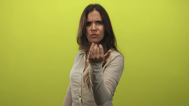Woman pointing finger at camera with furrowed brow and stern face in lime green studio; accusation demand accountability.
