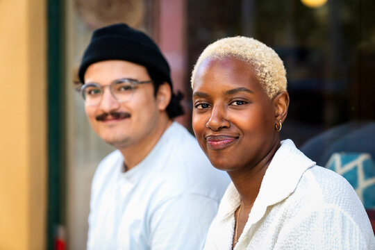 Portrait of smiling female owner with salesperson in background