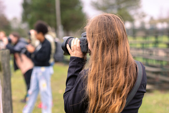 Woman photographer taking pictures of people with camera