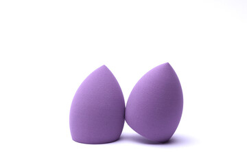 Makeup egg blenders of purple color on white background. Beauty concept.