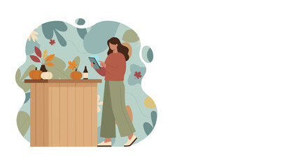 Woman uses tablet by a wooden counter with autumn decor including pumpkins and fall leaves