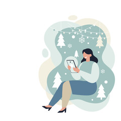 A woman uses a tablet in a cozy winter holiday setting with trees and lights Christmas shopping online