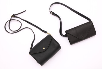 Two leather black bags with straps, white background