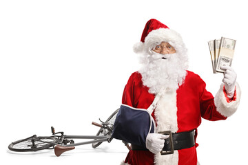 Santa Claus with a bicycle and arm injury holding money