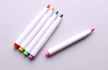 Set of colored markers on a gray background