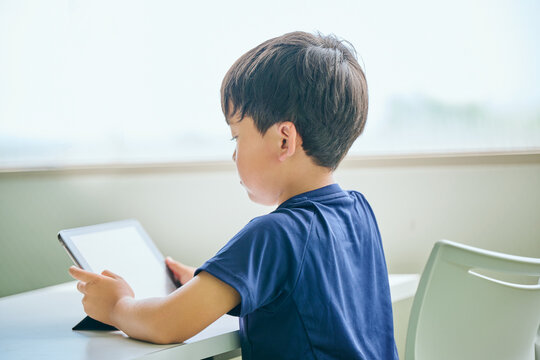 タブレットでオンライン学習をする小学生の男の子