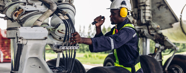 Aircraft workers checking airplane. Ground personnel at the airport check the hydraulic system of...