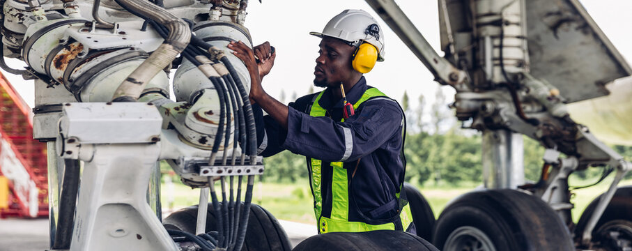 Aircraft workers checking airplane. Ground personnel at the airport check the hydraulic system of the landing gear of the aircraft