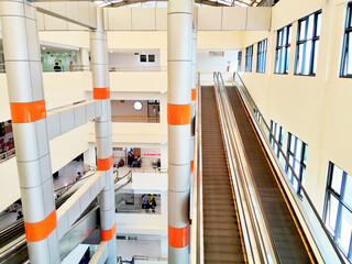Modern Multi Level Building Interior Featuring Long Escalators and Vertical Atrium Columns