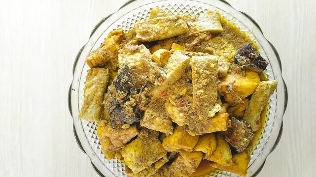 Close-up. Yellow smoked tuna fish, with red chili garnish and tomato slices. Food from Indonesia.