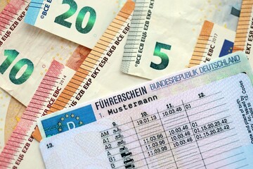 German driving license card called Fuhrerschein lies on big amount of european Euro money bills...
