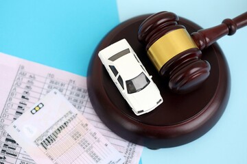 Generic driving license and judgement gavel on blue background close up