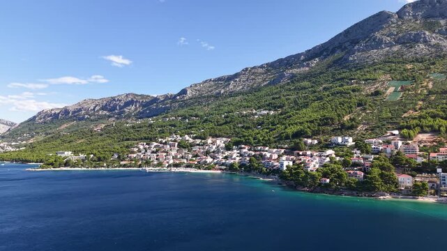 Elevated Perspective of a Charming Croatian Town in Makarska rivera, Where Dense Pine Forests Meet White Pebbled Shores and the Crystal-Clear Waters of the Adriatic