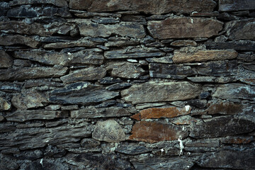 Vintage stone wall an old castle, dark background of slate bricks