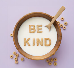 Naklejka premium “Be Kind” Cereal Letters in Milk Bowl on White Background