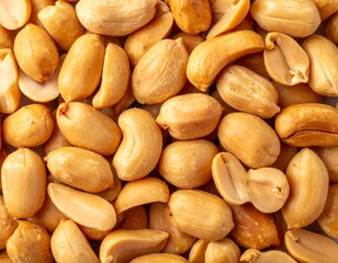 A close-up shot featuring a pile of golden-brown peanuts. Their smooth surface is inviting
