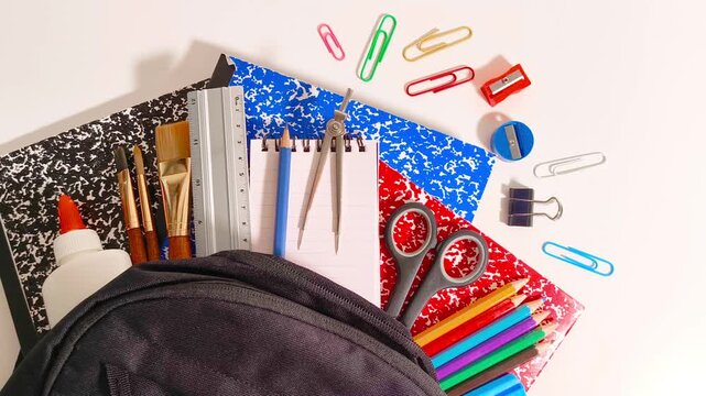 Back to school supplies with scissor, books, markers, colored pencil crayons, gel pens, ruler, sharpener, compass, calculator, notepad, paper clips in a backpack education, student, children, learning