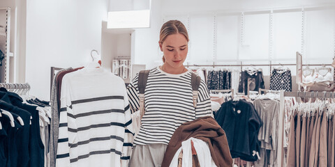 Black Friday. A woman in a store picking out clothes, the season of discounts and sales. A day of mega discounts, sale,Black Friday Shopping Week,Green Friday,cyber monday
