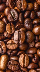 A close-up, textured view of roasted coffee beans. Browns, tans, and dark shades are featured