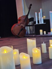 Burning candles on the stage where musical instruments are placed
