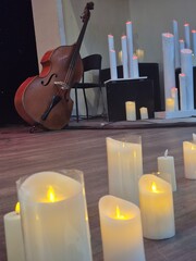 Burning candles on the stage where musical instruments are placed