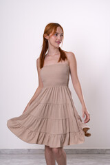 Naklejka premium red haired woman posing playfully and smiling in front of white background confident and natural studio portrait