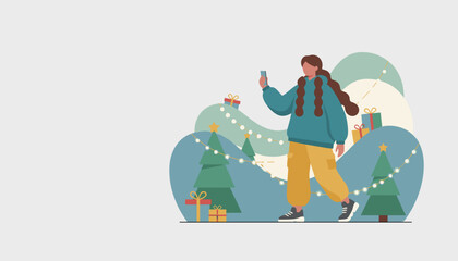 Young woman uses smartphone walking through festive Christmas landscape with trees and gifts