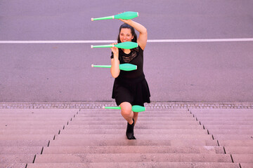 Eine junge Frau mit Keulen auf einer Treppe.