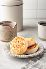 Cottage cheese pancakes or syrniki on ceramic plate on light gray kitchen table. Healthy sweet breakfast