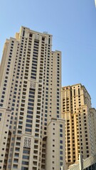 Fototapeta premium A vibrant Dubai city skyline featuring modern high-rise buildings, glass facades, and towering structures. The image captures the essence of urban development and architectural innovation in a bustlin