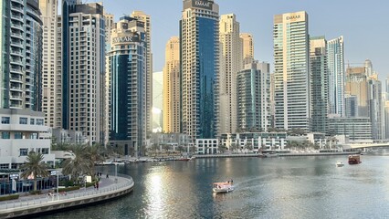 A vibrant Dubai city skyline featuring modern high-rise buildings, glass facades, and towering structures. The image captures the essence of urban development and architectural innovation in a bustlin