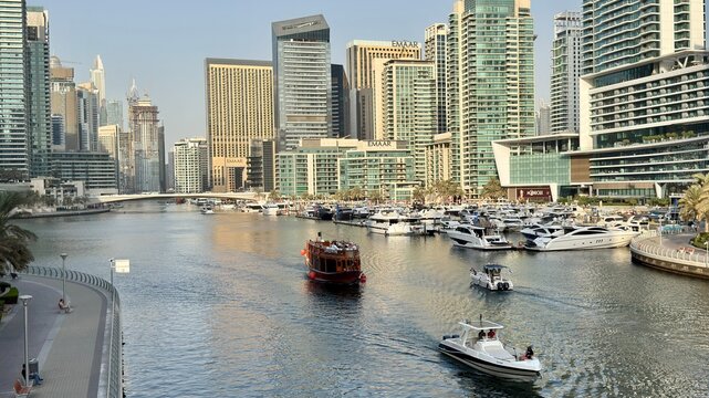 A vibrant Dubai city skyline featuring modern high-rise buildings, glass facades, and towering structures. The image captures the essence of urban development and architectural innovation in a bustlin
